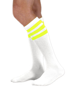 Unisex adult size white knee high tube sock with three fluorescent neon yellow stripes